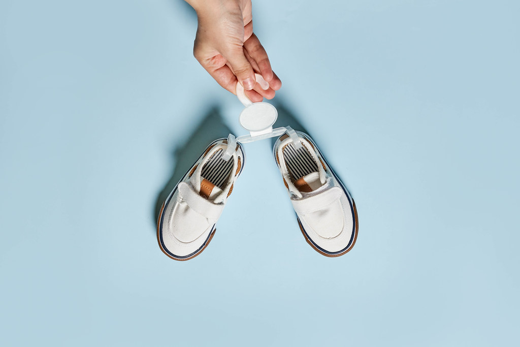 Female hands hold new shoes of baby boy Female hands hold new shoes of baby boy